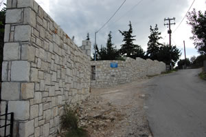 Tall stone boundary wall.